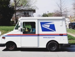 A United States Postal Service truck sitting outside on a suspiciously delightful day.