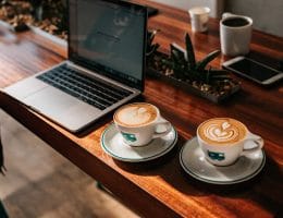 A student works hard while still finding time to enjoy a couple of lattes with latte art.