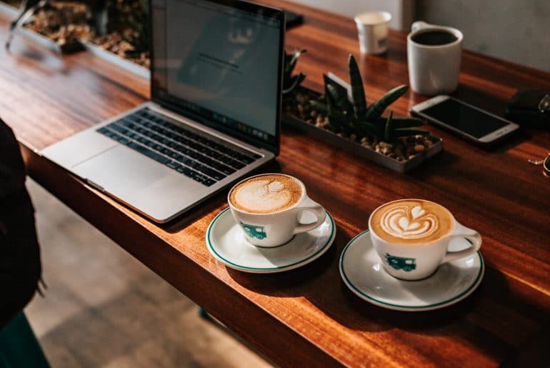 A student works hard while still finding time to enjoy a couple of lattes with latte art.