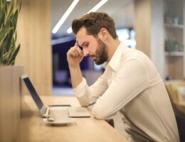 Bearded man is concentrating very hard on his online course. Will he pass?
