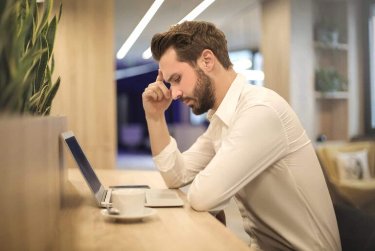 Bearded man is concentrating very hard on his online course. Will he pass?