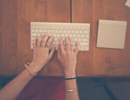 Woman typing her graduate school essay on a very small keyboard.