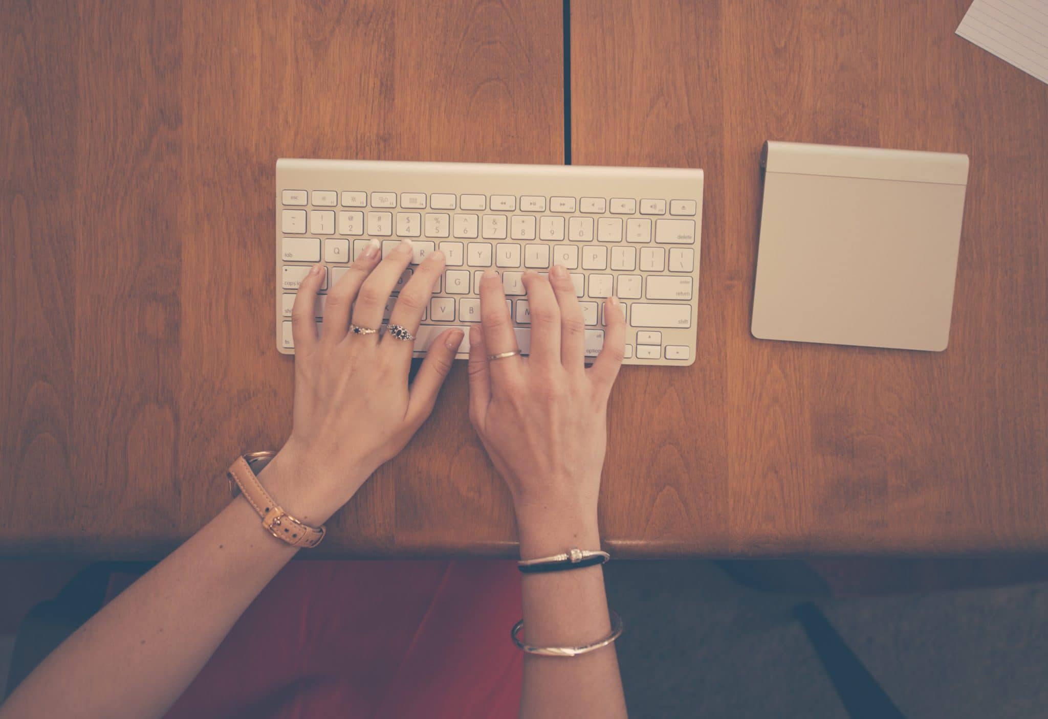 Woman typing her graduate school essay on a very small keyboard.