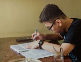 A man in a black shirt writing