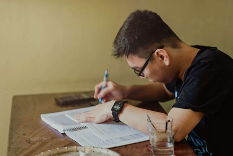 A man in a black shirt writing