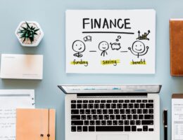 Desk with laptop and fun cartoon showing why finance is awesome