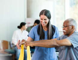 Therapist who went through occupational therapy college and now is working with an elder doing elastic band exercises