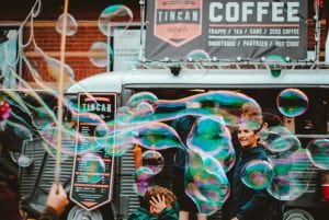 Students having fun making bubbles outside of a coffee shop