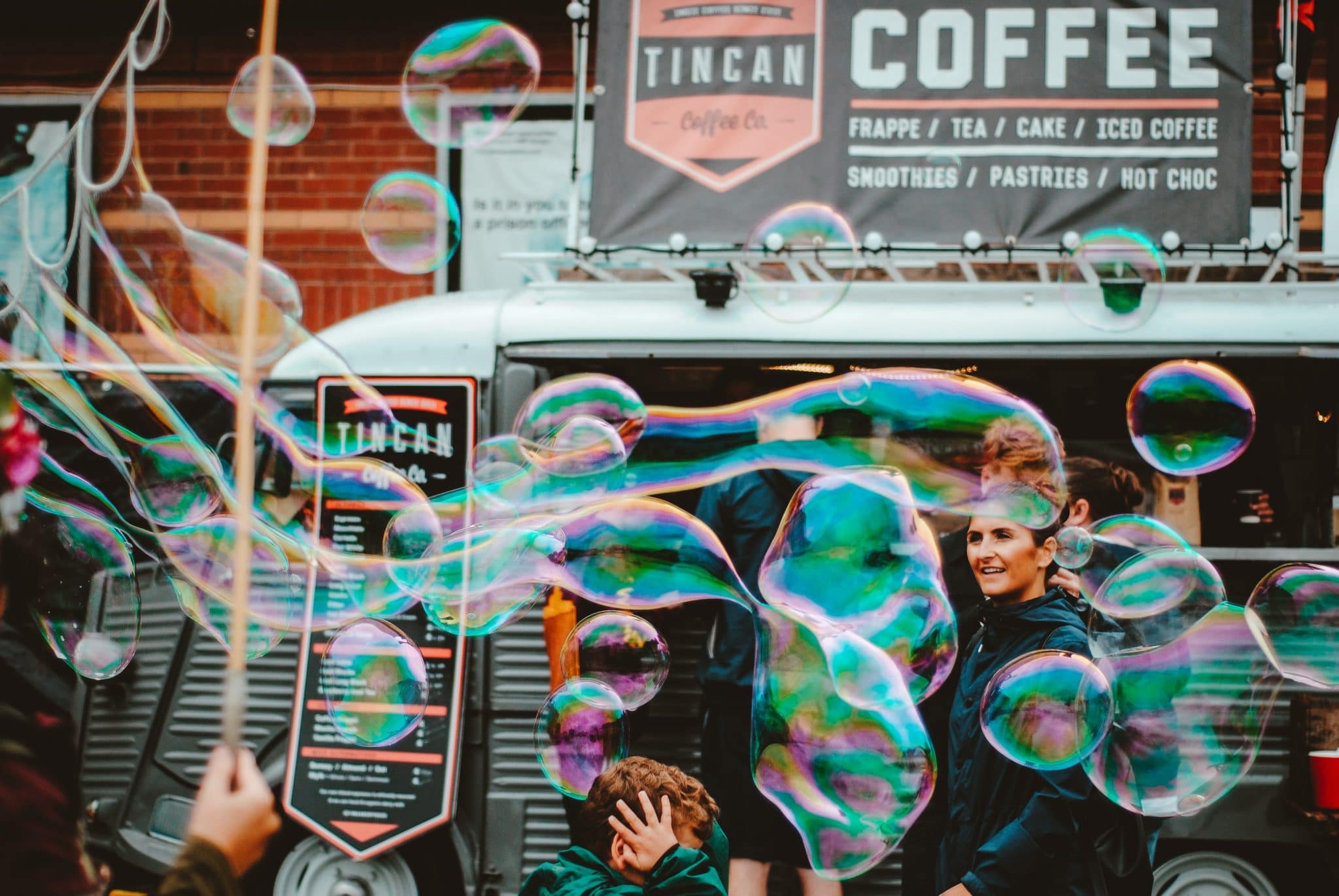 Students having fun making bubbles outside of a coffee shop