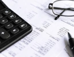 Investment and Financial analysis and reporting concept with Calculator, glass and pen. focus in center, selective.