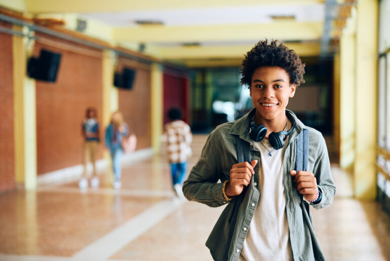 High School Student in hallway in between classes smiling at the opportunity to use reflection as an ACT test prep tool