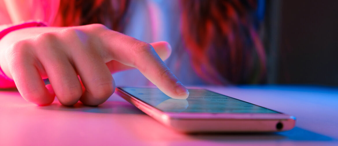 Gamification in Technology being shown through a young female presenting individual tapping their touchscreen.