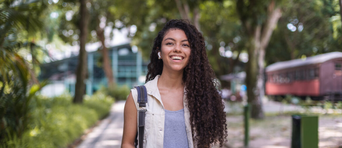 Student walking on college campus who decided whether to take both the ACT and SAT for College