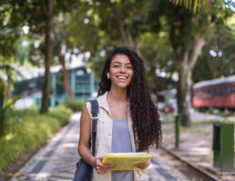 Student walking on college campus who decided whether to take both the ACT and SAT for College