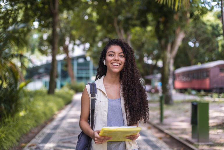 Student walking on college campus who decided whether to take both the ACT and SAT for College