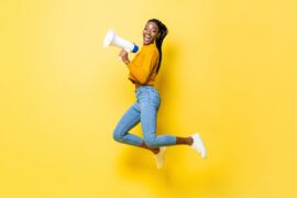 A female presenting student excited about being TOEFL test ready with a microphone