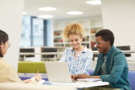 Students who are making student progress in their standardized test scores in a library through digital test prep