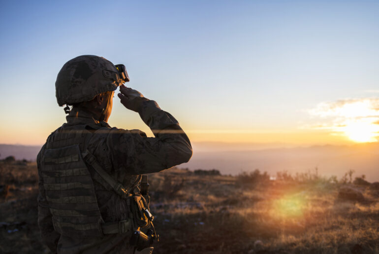Soldier Saluting her dream ASVAB scores with a sunset knowing she worked hard on her ASVAB practice test mistakes.