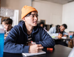 Student sitting at a desk with a smile on their face and clear study motivation
