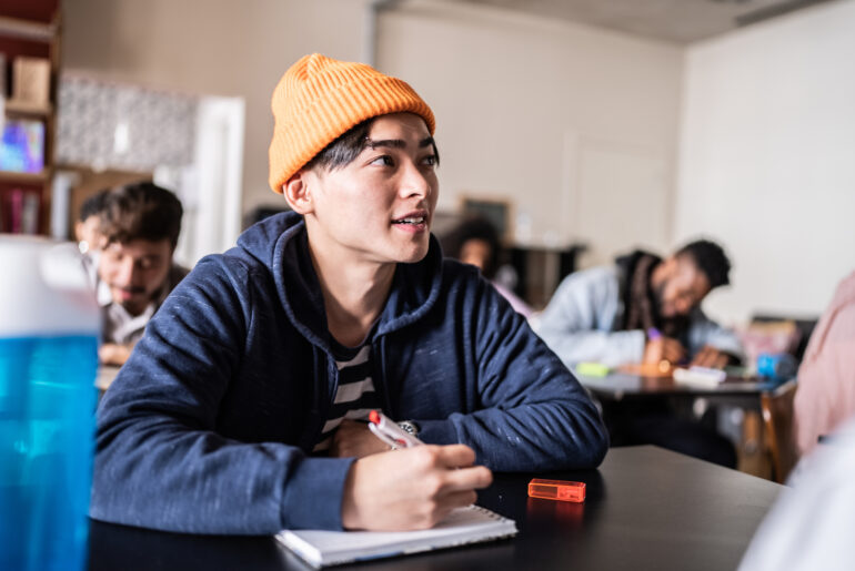 Student sitting at a desk with a smile on their face and clear study motivation