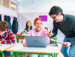 Teacher helping a student with a computer assignment