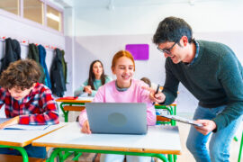 Teacher helping a student with a computer assignment