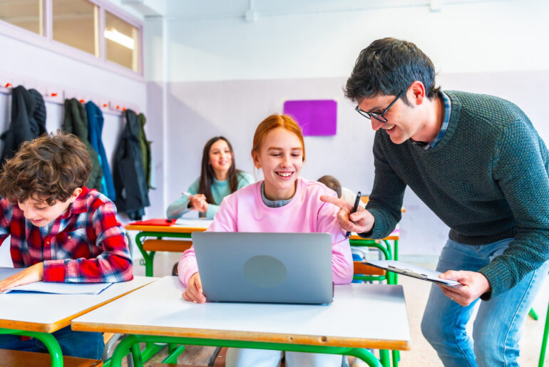 Teacher helping a student with a computer assignment