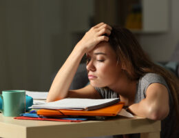 Student Upset with her AP test scores while looking at her books.