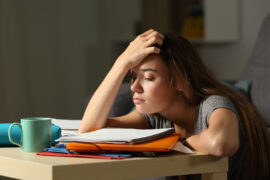 Student Upset with her AP test scores while looking at her books.